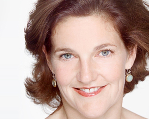 Headshot of Amanda Skoog. White female with short brown hair wearing hanging circle earrings.