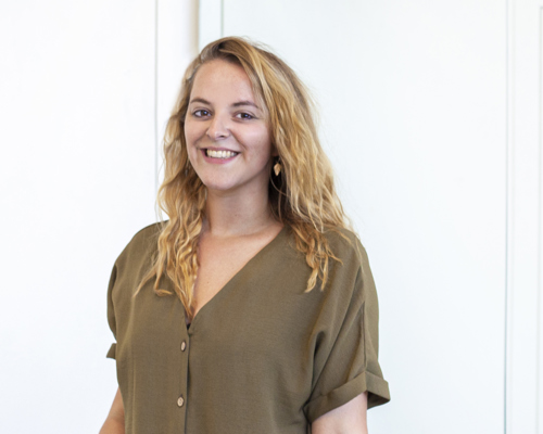 Headshot of Dani Bower. white female with long blond curly hair smiling at the camera