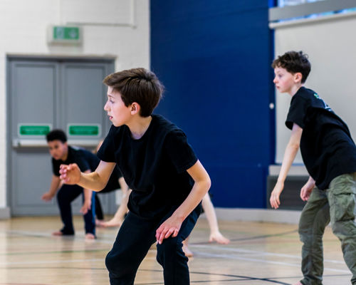 Three young boys dancing in a sports hall