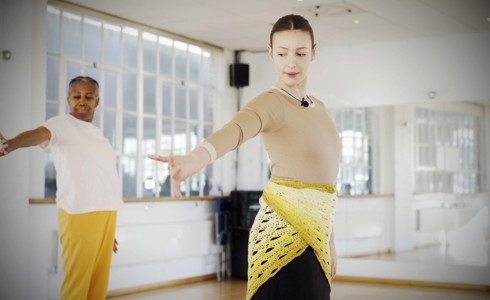 two female dancers long left hand out looking down in a mirrored dance studio