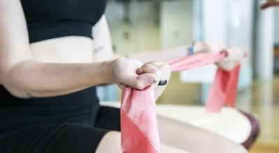 close up of dancer stretching resistant band between hands