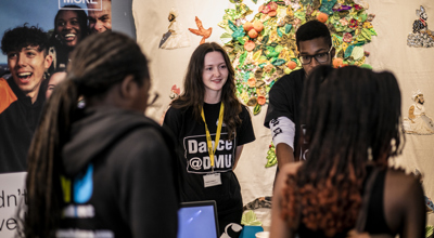 male and female manning an exhibition stand with pull up banners in the background
