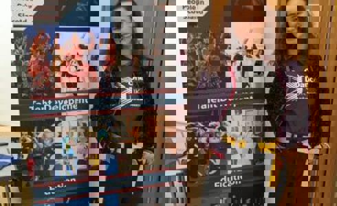 White female one dance uk dance ambassador standing in front of a Y Dance pull up banner